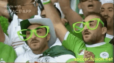 Men In Green Glasses And Hats Watching Soccer GIF