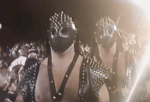 Men In Masks And Studded Outfits GIF
