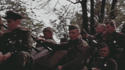 Men In Military Uniforms Sitting In Field GIF