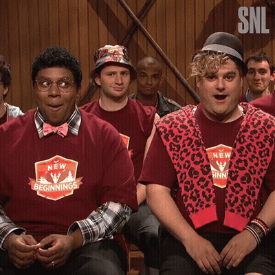 Men In New Beginnings Shirts Sitting In Room GIF