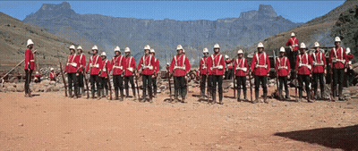 Men In Red Uniforms Lined Up With Mountains GIF