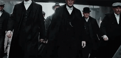 Men In Suits And Hats Walking Down City Street GIF