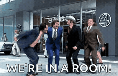 Men In Suits Dancing In Front Of Building Saying We're In A Room GIF