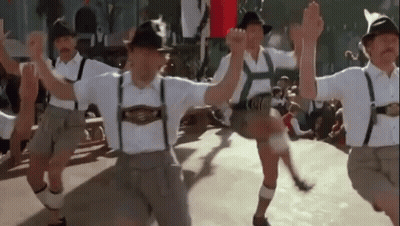 Men In Traditional German Clothing Dancing In A Line GIF