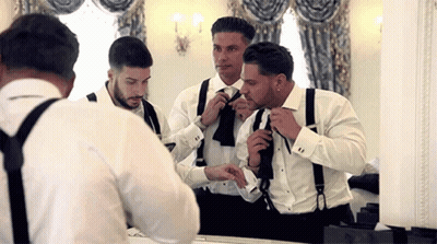 Men In Tuxedos And Suspenders Getting Ready In Front Of Mirror GIF