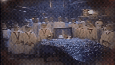 Men In White Robes Around Table With Picture GIF