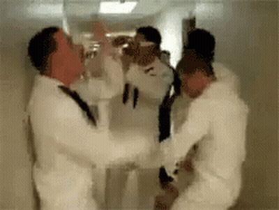 Men In White Suits Standing In Hallway GIF