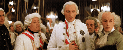 Men In Wigs Around Man In White Suit GIF