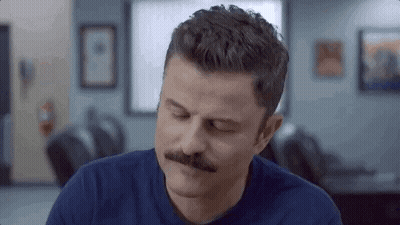 Men Laying On Bed With Sign Saying The Bed GIF