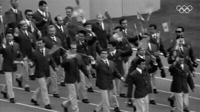 Men Marching In Parade With Olympic Rings GIF