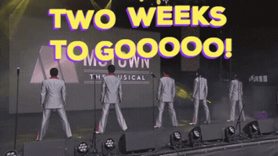 Men On Stage With Two Weeks To Gooooo Sign GIF