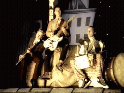 Men Playing Instruments In Front Of SD Sign GIF