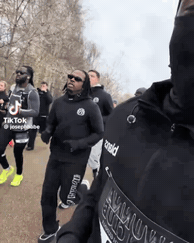 Men Running In Park One Wearing Armour Shirt GIF