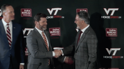 Men Shaking Hands In Front Of Farm Bureau Insurance Wall GIF