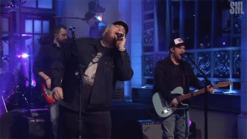 Men Singing And Playing Guitar On Stage GIF