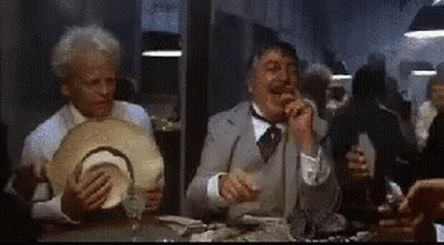 Men Sitting At Table Eating And Drinking In Dark Room GIF
