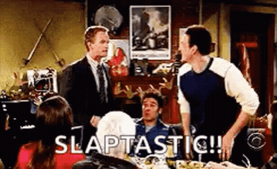 Men Sitting At Table With Slaptastic Sign GIF