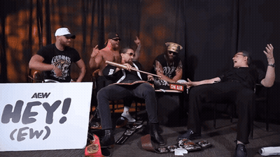 Men Sitting In Front Of Hey Ew Sign GIF