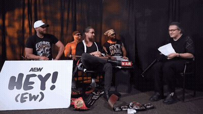 Men Sitting In Front Of Hey (Ew) Sign GIF