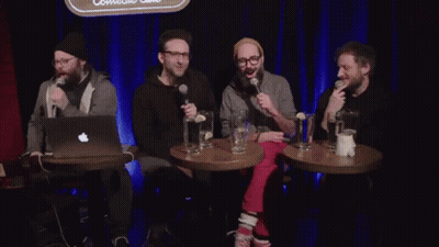 Men Sitting In Front Of Scoop Sign GIF
