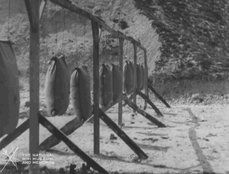 Men Stabbing Hanging Stuffed Sacks GIF