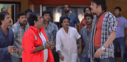 Men Standing Around Man In Red Jacket GIF