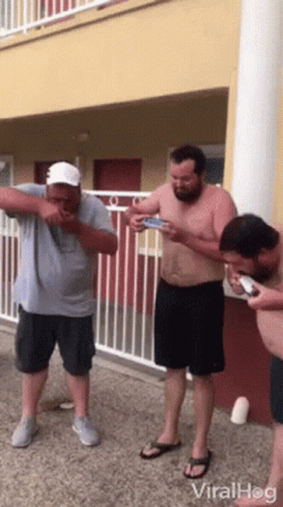 Men Standing In Front Of Building On Phones GIF