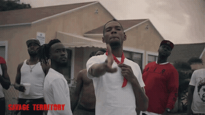 Men Standing In Front Of Building With Savage Territory GIF
