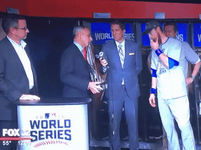 Men Standing In Front Of Fox World Series Sign GIF