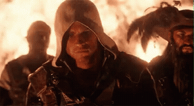 Men Standing Near Fire, One Hooded GIF