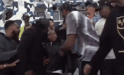 Men Surrounding Man In White Shirt With V GIF