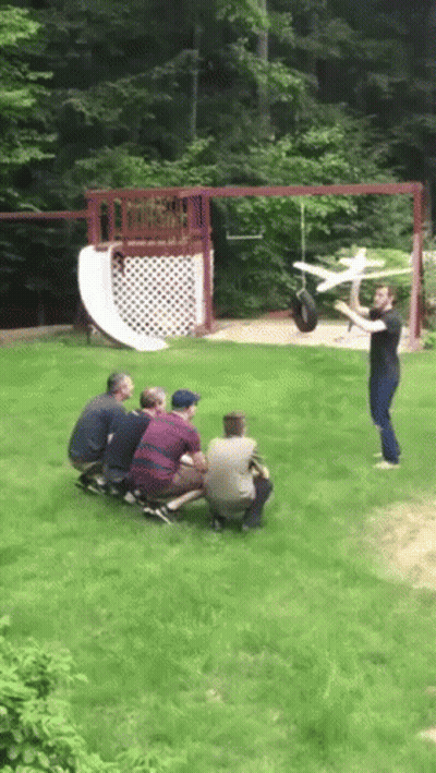 Men Watching Man Throwing Toy Airplane GIF