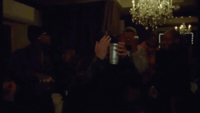 Men Waving Bottles In Dark Room GIF
