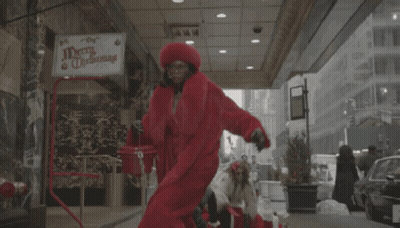 Merry Christmas Sign Above Woman in Red Coat