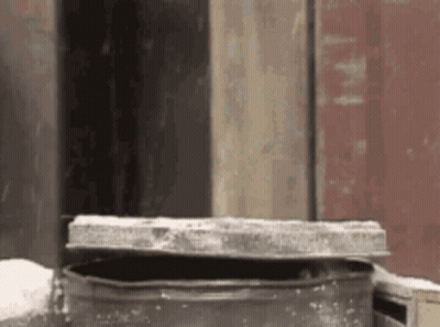 Metal Container With Lid In Front Of Building GIF
