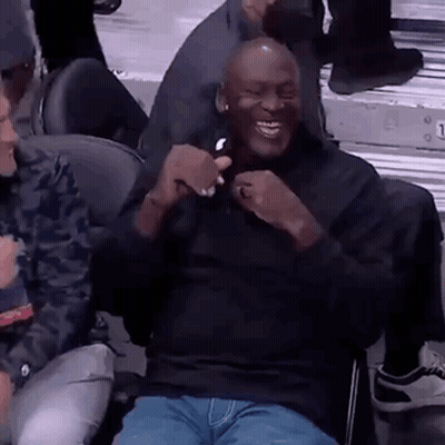 Michael Jordan Is Sitting In The Stands At A Basketball Game Laughing And Holding A Cell Phone . GIF