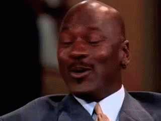 Michael Jordan Is Wearing A Suit And Tie And Smiling While Sitting In A Chair . GIF