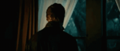 Michael Myers Is Standing In Front Of A Window In A Dark Room . GIF