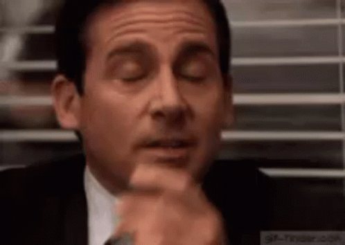 Michael Scott Is Sitting In Front Of A Window With His Eyes Closed And His Hand On His Chin . GIF