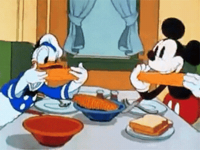 Mickey Mouse And Donald Duck Are Sitting At A Table Eating Sandwiches GIF