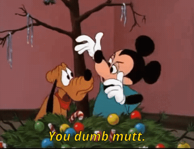 Mickey Mouse And Pluto Are Decorating A Christmas Tree And Mickey Is Saying You Dumb Mutt GIF