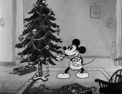 Mickey Mouse Is Decorating A Christmas Tree In A Black And White Cartoon In A Living Room . GIF