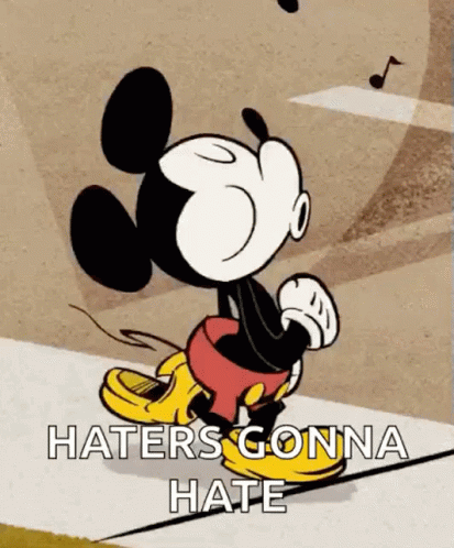 Mickey Mouse Is Walking Down A Sidewalk With The Words `` Haters Gonna Hate '' Written On It . GIF