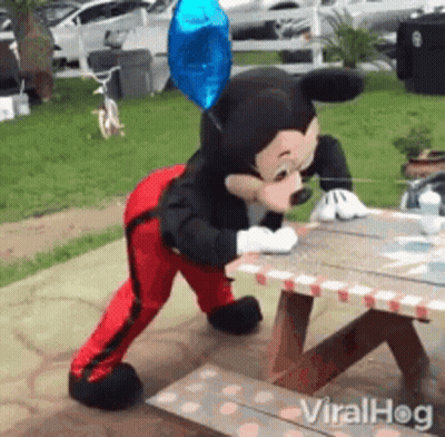 Mickey Mouse Mascot Standing On Picnic Table GIF