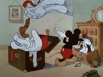 Mickey Mouse Next To Trunk Filled With Clothes GIF
