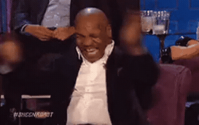 Mike Tyson Is Sitting In A Chair With His Arms In The Air And Smiling . GIF