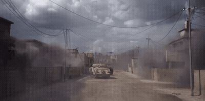 Military Vehicle Driving On Dirt Road Under Cloudy Sky GIF