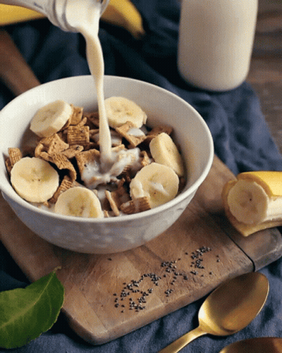 Milk Is Being Poured Into A Bowl Of Cereal GIF