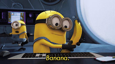 Minion Holding Banana In Front Of Keyboard Saying Banana GIF