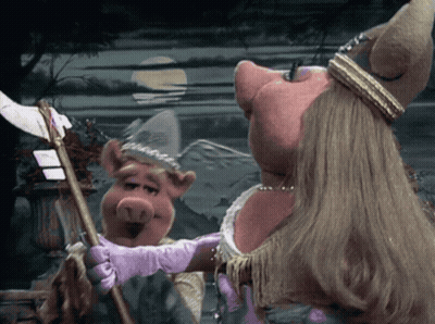 Miss Piggy Is Wearing A Purple Glove While Holding A Cane GIF
